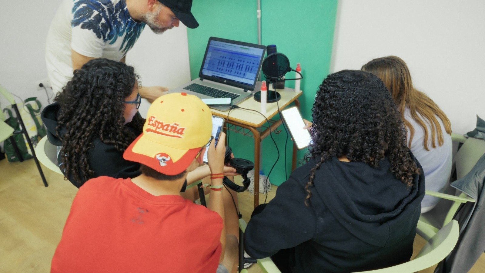 Taller juvenil de grabación y edición de audio – Raíces Vivas Jóvenes participando en un taller de grabación y edición de audio usando móviles, micrófono y ordenador.